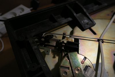Dziwny przełącznik obrotów. Jego funkcja działą na zasadzie przerzutki w rowerze, przenosi pasek wzdłuż wałka osi silnika na miejsce gdzie jego średnica jest większa (45rpm) lub mniejsza (33rpm). jednocześnie suwak pełni rolę regulatora obrotów poprzez zwiększenie tarcia na pasek.